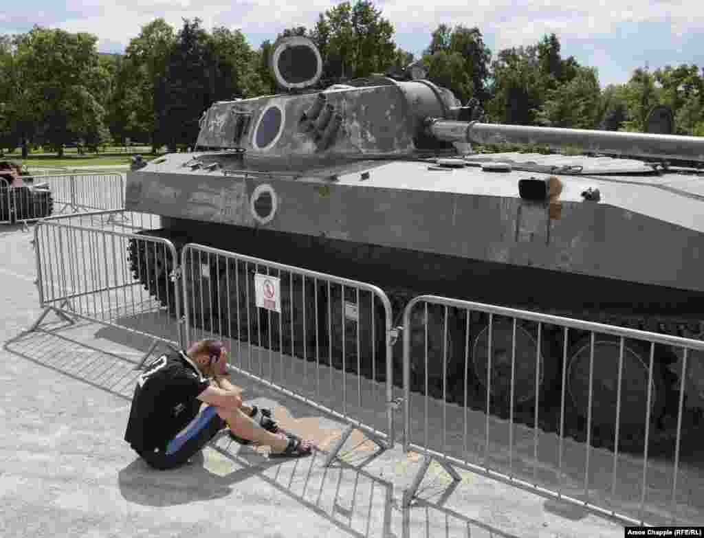 A man weeps next to a&nbsp;Khosta self-propelled mortar. The apparently grieving man was later spoken to by police after climbing onto one of the Russian vehicles.