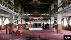 Personeli i sigurisë inspekton një tempull të dëmtuar Sikh-Hindu së bashku me përfaqësuesit e medias, pas një sulmi të mëparshëm kundër pakicave fetare në Kabul në mars 2020.