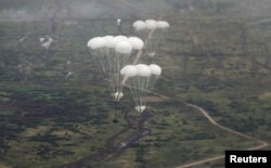 Pogled iz transportnog vojnog aviona na ruska borbena vozila kako se spuštaju padobranom tokom vježbi 'Zapad-2021' koje su organizovale oružane snage Rusije i Bjelorusije u Kaljiningradskoj oblasti, Rusija, 13. septembar 2021.