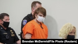 Policajci uvode Pejtona Gendrona u sudnicu u okrugu Iri u Bafalu, 19. maja 2022. 