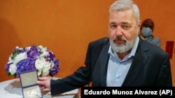 Dmitrij Muratov pokazuje fotografima svoju Nobelovu nagradu pred aukciju u New Yorku, 20. juni 2022.