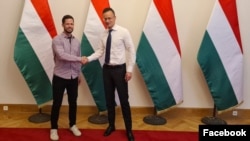 Szijjártó Péter és Tordai Bence 2021-ben, az OPNI-házak lakóinak ügyében folytatott megbeszélés után egymás tenyerébe csapott