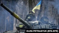 Un tanc ucrainean T-72 manevrează prin pădure, în regiunea Donețk, 18 ianuarie 2023. Ministrul britanic al apărării a confirmat că Marea Britanie va trimite Ucrainei 14 tancuri Challenger 2.