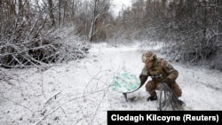 Një ushtar ukrainas duke e shkyçur një marrës të Starlinkut pranë vijës së frontit në lindje të Ukrainës.