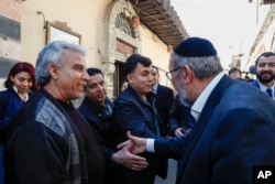Жители центра Дамаска, разных национальностей и конфессий, приветствуют раввина Иосифа Хамра (справа), члена семьи сирийско-американских евреев, которая вернулась в страну впервые после эмиграции из Сирии в Соединенные Штаты более трех десятилетий назад. 18 февраля 2025 года