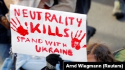 Берн, Швајцарија- Демонстрант држи транспарент за време на антивоенот протест против инвазијата на Русија врз Украина 26 февруари 2022 година
