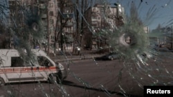 Линейка в Киев се вижда през продупчен от снаряди прозорец. На дванайстия ден от руската инвазия в Украйна столицата на страната остава под украински контрол.