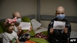 Деца показват надписи "Спрете войната" в бомбоубежището на онкологичен център в Киев, 28 февруари 2022.