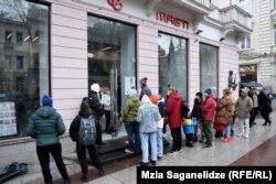 მიგრანტების რიგი თბილისში ტელეფონის ნომრის ასაღებად.