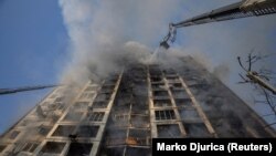 Vatrogasci pokušavaju da ugase požar u jednoj od stambenih zgrada u Kijevu koju je pogodila ruska vojska, mart 2022. 