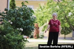 Hamida Gaši pored ruža na mestu gde je ubijen njen sedmogodišnji sin Votimi.