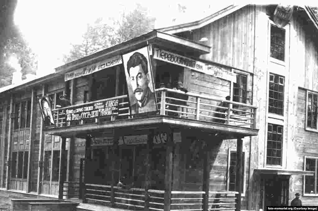 Полициска зграда во работен логор Томск во 1934 година. На балконот се портрети на советскиот водач Јозеф Сталин (десно) и Феликс Џержински, полско-советски комунист и шеф на тајната полиција зад масовните политички убиства познати како Црвениот терор. Паролите на зградата ја вклучуваат фразата: &bdquo;Само во земјата на Советите е можно да се реформира човек преку труд&ldquo;.