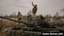 Ukrajinski vojnik snima selfie fotografiju dok stoji na uništenom ruskom tenku nakon što su ukrajinske snage zauzele rusku poziciju ispred Kijeva 31. marta 2022.