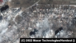 Fumul se ridică deasupra unor zone rezidențiale distruse din sudul orașului port Maripol, pe 29 martie 2022. Imagine oferită de Maxar Technologies.