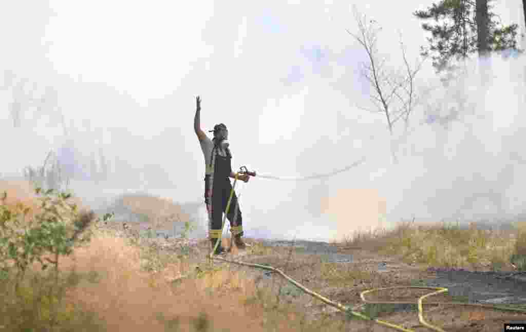 Egy tűzoltó dolgozik az erdőtűz oltásán a Drezdától északra fekvő Thiendorf közelében, Németországban 2022. július 19-én