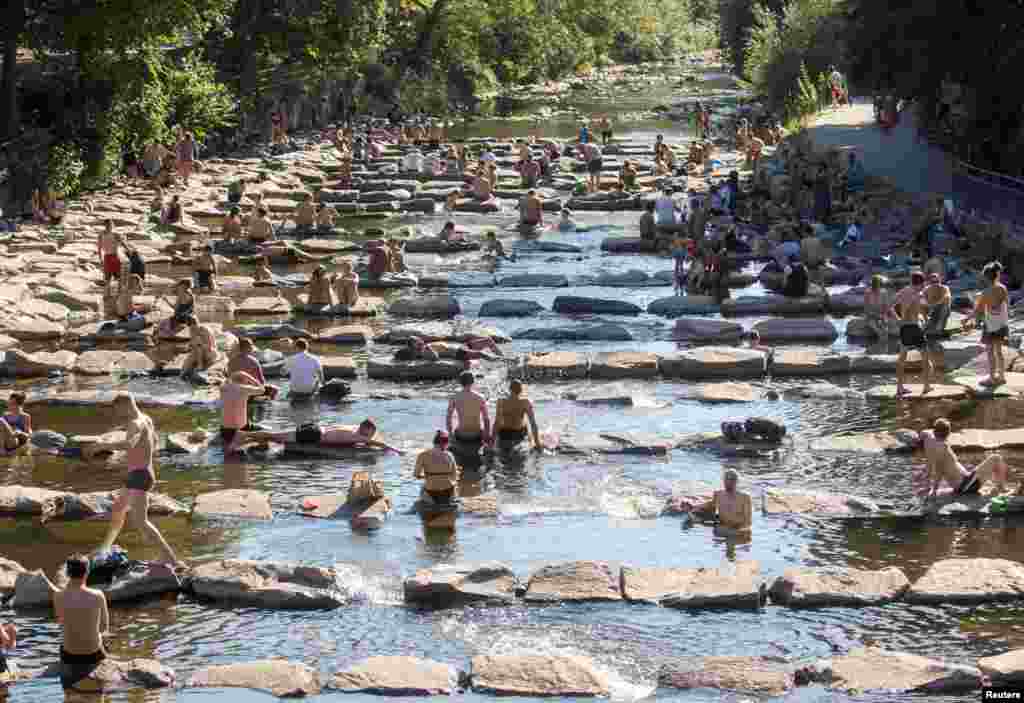 Emberek hűsölnek a Dreisam folyóban Freiburg im Breisgau-ban, Németországban 2022. július 19-én. A városokban sokkal nehezebb lesz átvészelni a hirtelen hőhullámokat, állítják a szakértők