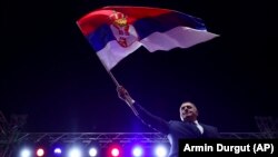 Milorad Dodik boszniai szerb vezető a szerb zászlót lengeti a boszniai Banja Lukában összegyűlt több ezer ember előtt október 25-én.