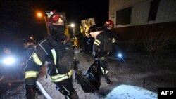 Pompieri ducând trupul neînsuflețit al unui civil în urma unui atac rusesc cu dronă la Harkov, pe 29 martie 2025