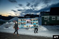 Un poster al Partidului Democraților (Demokraatit) în preajma unei secții de votare din Nuuk, la 11 martie 2025.