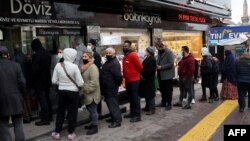 Egy ankarai pénzváltó előtt sorakoznak az emberek 2021. december 20-án
