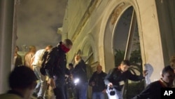 Libijske vlasti i mediji kreću se kroz ruševine zgrada nakon vazdušnih napada NATO na Tripolij, 10. maj 2011.