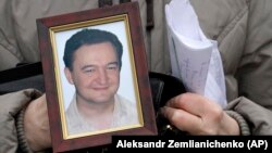 A portrait of lawyer Sergei Magnitsky, who died in jail, is held by his mother, Natalia Magnitskaya, in Moscow in November 2009.