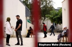 ავღანელი ლტოლვილები - 25 წლის ასმა ჰალიმი და 29 წლის მოჰამედ ომერ აიუბი - საუბრობენ რაზაის მიმღები ცენტრის ეზოში. 30 აგვისტო, საფრანგეთი, პირიაკ-სურ-მერი.