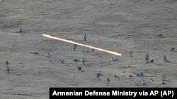 Този кадър е взет от видео, разпространявано от арменското правителство. То е от 13 септември и се вижда обстрела между войници от Армения и от Азербайджан. 