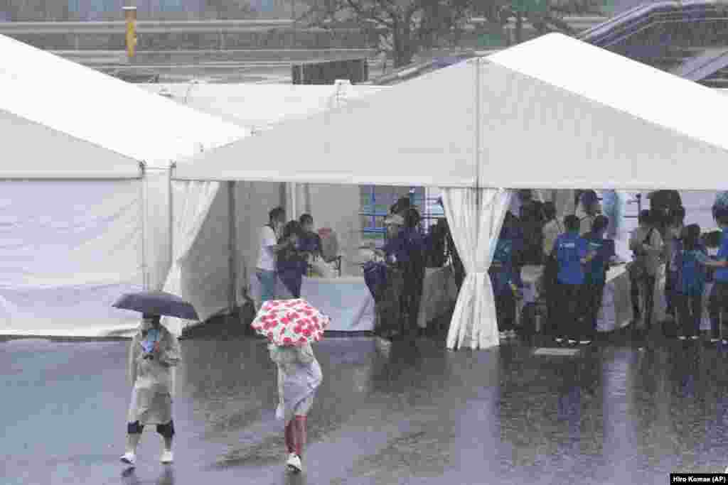 Ljubitelji tenisa ulaze na mjesto održavanja teniskog turnira u Tokiju, u ponedjeljak, 19. septembra 2022. Tropska oluja zahvatila je jugozapadni Japan sa padavinama i vjetrovima u ponedjeljak, dok je skretala na sjever prema Tokiju.