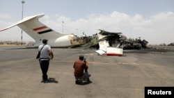 Media photographers take pictures of a destroyed plane at Sanaa International Airport in the aftermath of an Israeli airstrike earlier this month. 