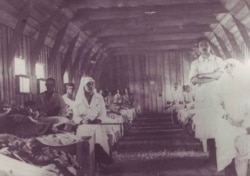 Răniți și infirmiere într-un spital de campanie din Moldova, 1917. (Sursa: Expoziția Marele Război, 1914-1918, Muzeul Național de Istorie a României, http://www.marelerazboi.ro/razboi-catalog-obiecte/item/crucea-rosie-4)