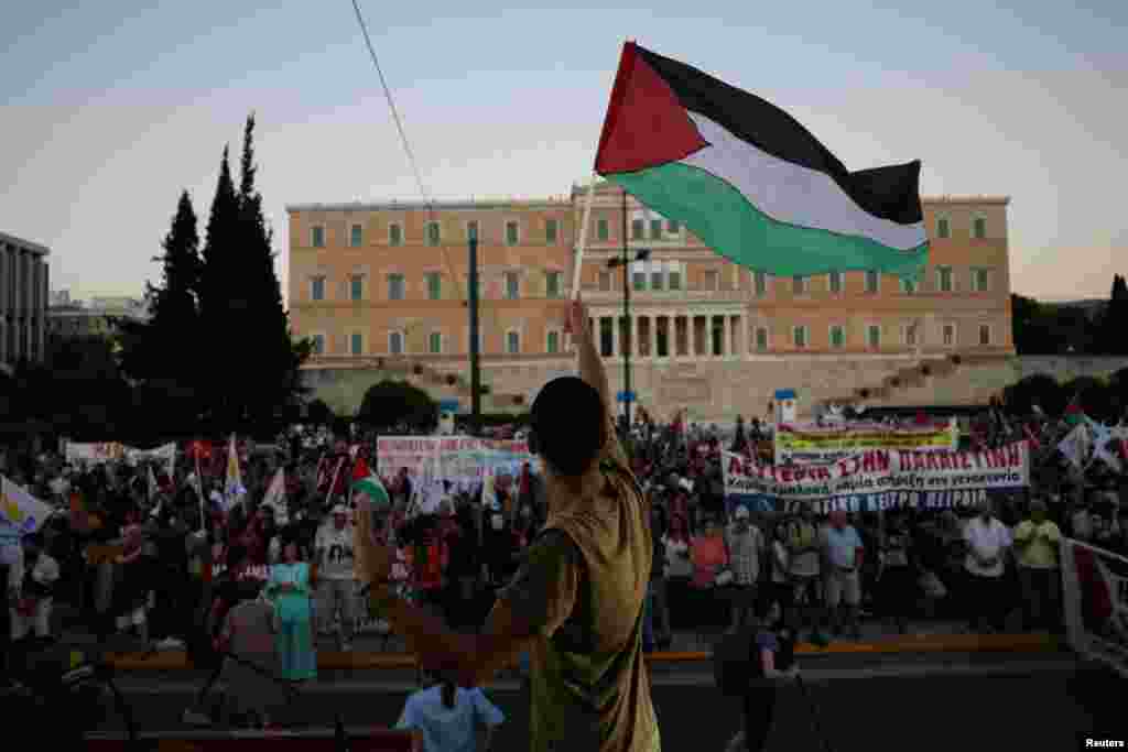 Një demonstrues propalestinez valëvit flamurin palestinez përpara parlamentit grek, gjatë një proteste në mbështetje të palestinezëve në Gazë. Athinë, Greqi, më 24 gusht 2025.