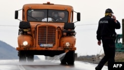 Policajac razgovara na mobitel, ulaz u Opštinu Tuzi, 25. mart 2020. godine.