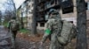 Ukrainian servicemen walk near an apartment building damaged by a Russian military strike in the frontline city of Kostyantynivka, in the Donetsk region on November 1.