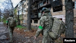 Ukrainian servicemen walk near an apartment building damaged by a Russian military strike in the frontline city of Kostyantynivka, in the Donetsk region on November 1.