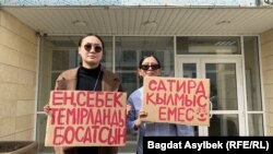 Активисты, пришедшие поддержать Темирлана Енсебека, держат плакаты, надписи на которых призывают освободить его. 9 апреля 2025 года