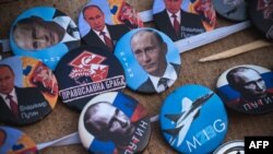 Një shitës ambulant, duke shitur distinktivë me fotografinë e presidentit rus, Vladimir Putin, gjatë një proteste të organizuar nga ultra-nacionalistët serbë në Beograd në prill të vitit 2022.
