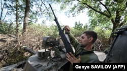 Un soldat de artilerie ucrainean, conducând un Howitzer 2S3 Akatsiya în regiunea Nikolaiev din sudul Ucrainei, 19 septembrie 2022.