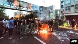 Iranski demonstranti pale kantu za smeće u glavnom gradu Teheranu tokom protesta, 21. septembar 2022.