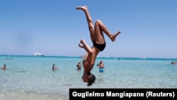 A Palermo melletti Mondello strandon szaltózik egy férfi 2020. július 31-én