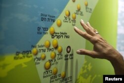 Žena gleda kartu na kojoj su prikazana bivša jevrejska naselja Guš Katif u Gazi, u centru za posjetioce u Nitzanu blizu Ashoda u Izraelu, avgust 2015.