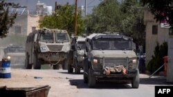 Vehicule blindate ale armatei israeliene intră în orașul palestinian Jenin în timpul unei operațiuni militare în nordul Cisiordaniei ocupate, pe 21 mai 2025.
