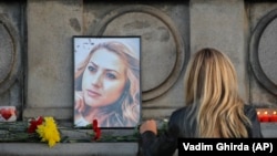Žena ostavlja cvijet ispred portreta ubijene bugarske novinarke Viktorije Marinove tokom skupa na kojem joj je odata počast u gardu Ruse 8. oktobra 2018.