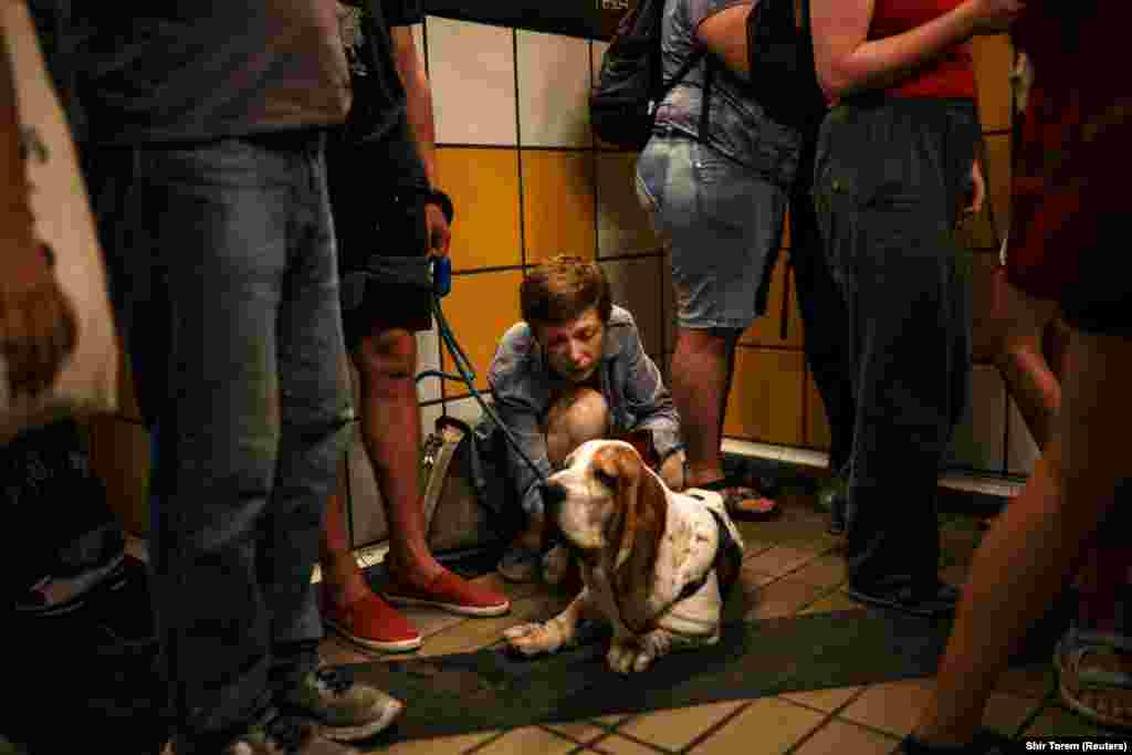 Një grua izraelite duke përkëdhelur një qen, teksa njerëzit strehoheshin brenda një tuneli teleferiku, pas një sulmi raketor nga Irani ndaj Izraelit, në Haifa, më 17 qershor.