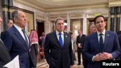 Secretarul de stat american, Marco Rubio, și ministrul rus de Externe, Serghei Lavrov, la discuțiile de la Palatul Diriyah, din Riad, din 18 februarie 2025. Între ei, consilierul prezidențial rus, Iuri Ușakov.