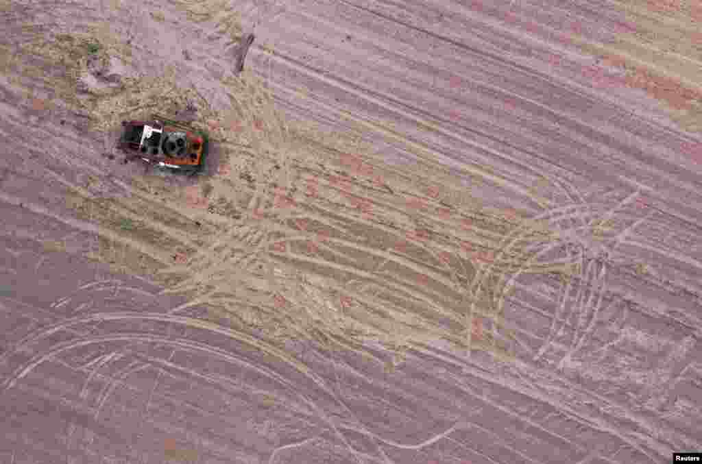 Uništeno vojno vozilo u prethodno miniranom žitnom polju u Černihovu, na severu Ukrajine, krajem maja. U uobičajenoj poljoprivrednoj sezoni, ukrajinski farmeri radili bi po striktnom rasporedu. Sada, oni moraju da sačekaju da bude dovoljno bezbedno za setvu. Često to bude tokom noći, pod okriljem mraka. Teškoće s kojima se suočavaju poljoprivrednici su brojne: nestašica dizel goriva, neselektivni artiljerijski udari, mine, ugljenisani ostaci oklopnih vozila na njihovim poljima, kao i nedostatak ljudstva. &nbsp;