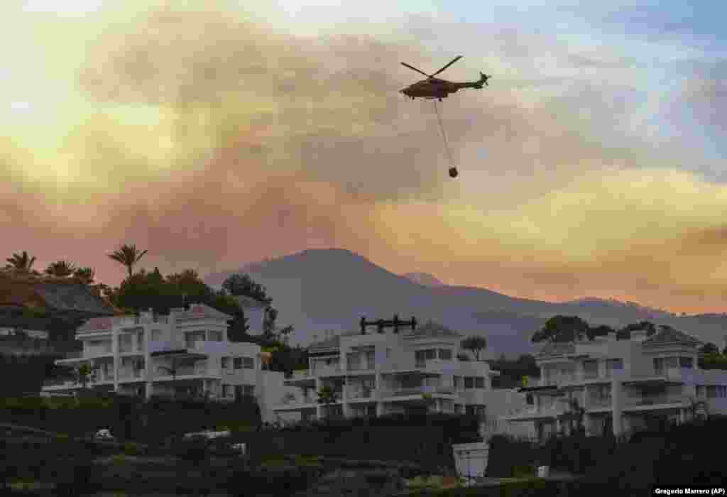 A forró nyári időjárás és a kedvezőtlen szélirány tovább szítja a tüzet &ndash; áll a spanyol hatóságok közleményében. Helikopterrel próbálják oltani a lakott terület közelében tomboló erdőtüzet a malagai Marbellában 2022. június 9-én