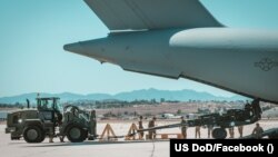 Un obuzier M777 american destinat Ucrainei, încărcat într-un avion de transport militar la baza aeriană March, California, 8 iunie 2022