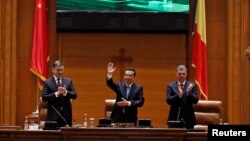 Premierul Chinei, Li Keqiang, salută parlamentarii români între președintele Senatului, Crin Antonescu (stânga) și președintele Camerei Deputaților, Valeriu Zgonea (dreapta), după ce s-a adresat Parlamentului României. 27 noiembrie 2013.
