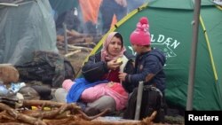 Migrantkinja sa djetetom ispred šatora u bjeloruskoj regiji Hrodno pored granice sa Poljskom, 10. novembar 2021. 
